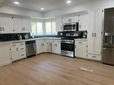 a large kitchen with white cabinets and appliances at Private Hillside Home with View - Yaamava - NOS in San Bernardino