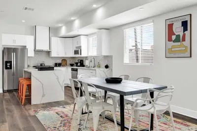 a kitchen with white cabinets and a table and chairs at LA Rooftop Paradise 2 in Los Angeles