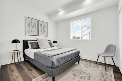 a white bedroom with a bed and a chair at LA Rooftop Paradise 2 in Los Angeles