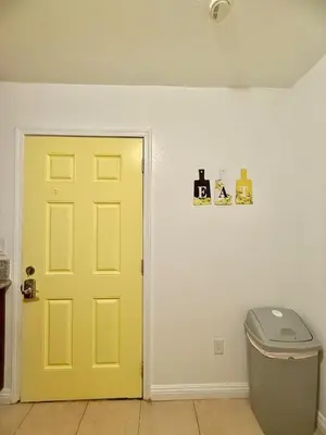 a yellow door in a room with a trash can at Lemon Studio with Mountain view in Rosemead