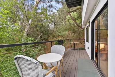 a balcony with a table and chairs and trees at Designer Laurel Canyon Retreat, Hollywood Hills in Los Angeles