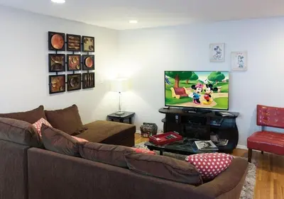 a living room with a couch and a flat screen tv at MagicwayVillas Mickey's Pool Club House - Pool & Spa - Walking to Disneyland in Anaheim