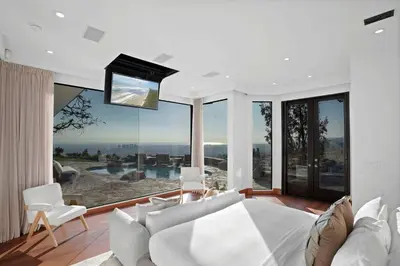 a living room with a white couch and a large window at Serene by Stay Awhile Villas in Los Angeles