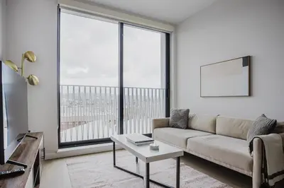 a living room with a couch and a large window at Blueground Downtown elevator nr parks LAX-1238 in Los Angeles