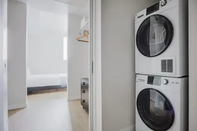 two washing machines are stacked on a wall in a room at Blueground Downtown elevator nr parks LAX-1238 in Los Angeles