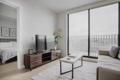 a living room with a bed and a large window at Blueground Downtown elevator nr parks LAX-1238 in Los Angeles