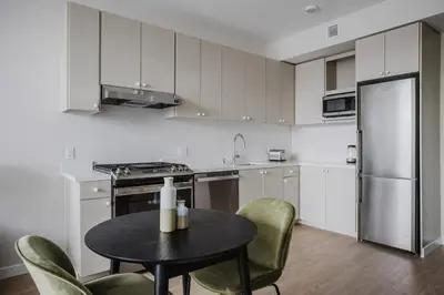 a kitchen with a table and chairs and a refrigerator at Blueground Downtown elevator nr parks LAX-1238 in Los Angeles