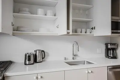 a kitchen with white cabinets and a sink at Blueground Downtown elevator nr parks LAX-1239 in Los Angeles