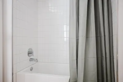 a bathroom with a tub and a shower curtain at Blueground Downtown elevator nr parks LAX-1239 in Los Angeles