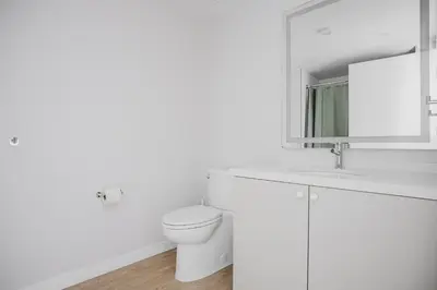 a white bathroom with a toilet and a sink at Blueground Downtown elevator nr parks LAX-1239 in Los Angeles