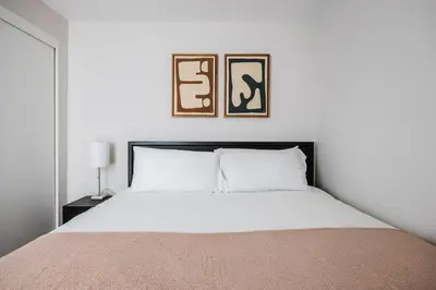 a bedroom with a bed with two pictures on the wall at Blueground Downtown elevator nr parks LAX-1240 in Los Angeles