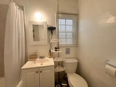 a white bathroom with a toilet and a sink at Del in Los Angeles
