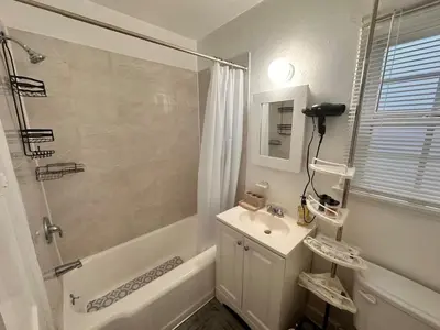a white bathroom with a sink and a shower at Del in Los Angeles