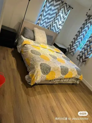 a bed with a comforter and pillows in a bedroom at Luxury suite private entrance in Hacienda Heights