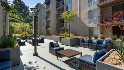 an outdoor patio with couches and tables and a building at Style, Peace, Comfort in N Hollywood Next to Burbank Free Indoor Parking and Wifi in Burbank