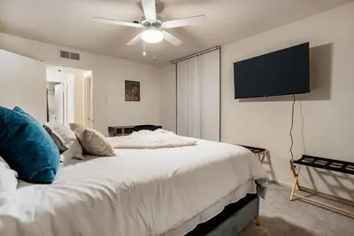 a bedroom with a white bed and a flat screen tv at Style, Peace, Comfort in N Hollywood Next to Burbank Free Indoor Parking and Wifi in Burbank