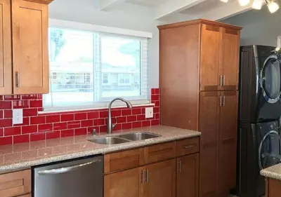 a kitchen with a sink and a red tile wall at MagicwayVillas Star Wars House - Walking Distance to Disneyland in Anaheim