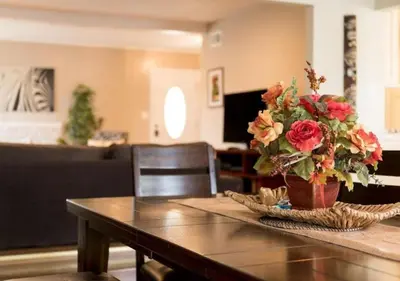 a table with a vase of flowers on top of it at Tiki House and Spa - Walking Distance to Dsineyland in Anaheim