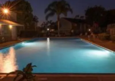 a large swimming pool lit up at night at Magicway Villas Mini's Poolside and Spa - Across Disneyland in Anaheim