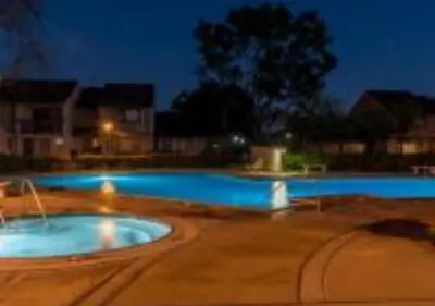 a large swimming pool at night with blue lights at Magicway Villas Mini's Poolside and Spa - Across Disneyland in Anaheim