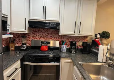 a kitchen with white cabinets and a stove top oven at MagicwayVillas Mick's ClockHouse Pool & Spa - Walk to Disneyland in Anaheim