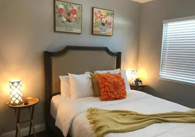 a bedroom with a bed with orange pillows on it at Magicwayvillas Micky's HideAway in Fullerton