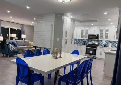 a kitchen and living room with a table and blue chairs at MagicwayVillas HeroHouse Pool and Spa in Fullerton