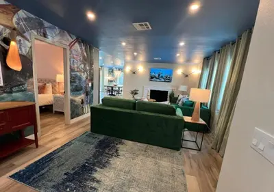 a living room with a green couch and a bedroom at MagicwayVillas Avetar Villa - 5 Bedroom 3 Bath - Spa and Splash Pad in Anaheim