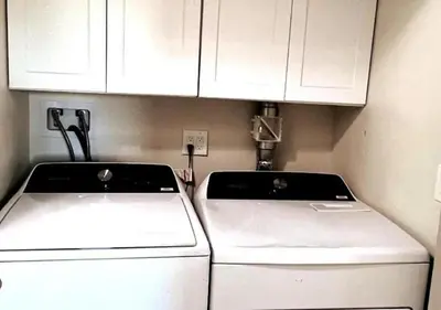 a kitchen with white cabinets and a washer and dryer at MagicwayVillas Avetar Villa - 5 Bedroom 3 Bath - Spa and Splash Pad in Anaheim