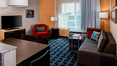 a hotel room with a couch and a chair and a television at TownePlace Suites by Marriott Bakersfield West in Bakersfield