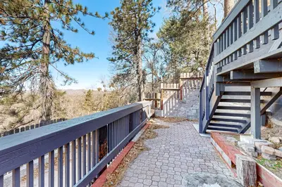 a staircase leading up to a building with a fence at Arosa Pines in Crestline