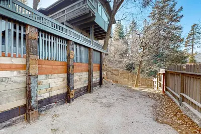 a wooden house with a fence and a gate at Arosa Pines in Crestline