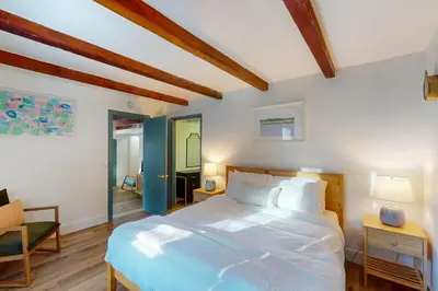 a bedroom with a large white bed and a chair at Arosa Pines in Crestline