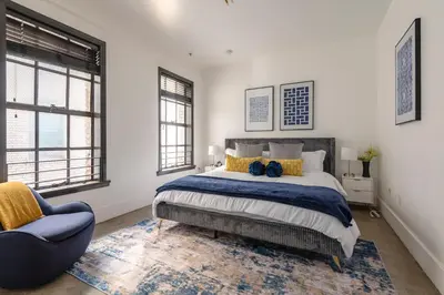 a bedroom with a large bed and a blue chair at Urban Luxe LOFT in Los Angeles
