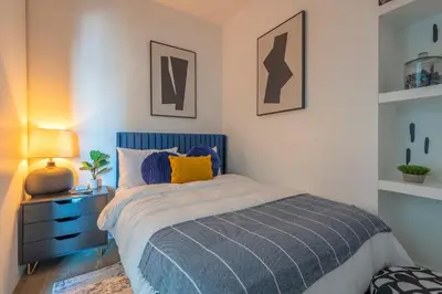 a bedroom with a bed with a blue head board at Urban Luxe LOFT in Los Angeles