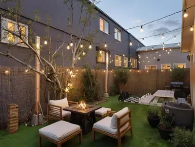 a patio with chairs and a table with lights at Fire Pit & Game Room 4 Beds Near Beach, LAX & SoFi in Lawndale