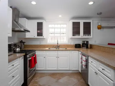 a kitchen with white cabinets and a sink at Fire Pit & Game Room 4 Beds Near Beach, LAX & SoFi in Lawndale