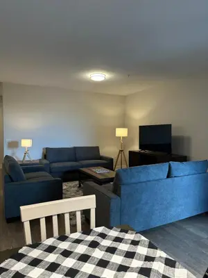 a living room with two blue couches and a tv at Avalon Wilshire in Los Angeles
