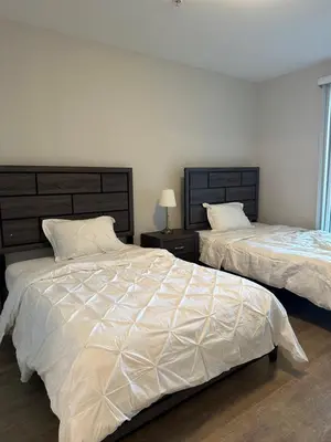 a bedroom with two beds with white comforter at Avalon Wilshire in Los Angeles