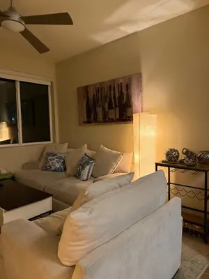 a living room with two couches and a ceiling fan at Wilshire La Brea Apartments in Los Angeles