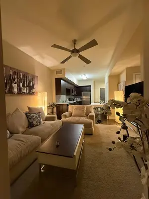 a living room with a couch and a ceiling fan at Wilshire La Brea Apartments in Los Angeles