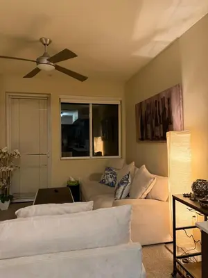 a living room with a couch and a ceiling fan at Wilshire La Brea Apartments in Los Angeles