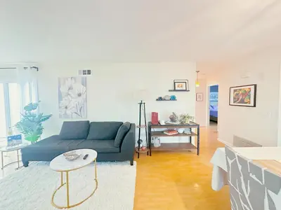 a living room with a blue couch and a table at Brea Mall romantic two-bedroom house in Fullerton