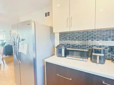 a kitchen with a refrigerator and a microwave at Brea Mall romantic two-bedroom house in Fullerton