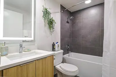 a bathroom with a sink and a toilet and a tub at Spacious 2BDR in SM - 5 minutes walk to the beach! in Los Angeles