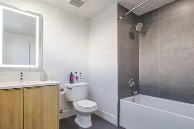 a bathroom with a toilet and a sink and a tub at Spacious 2BDR in SM - 5 minutes walk to the beach! in Los Angeles