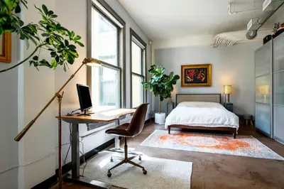 a bedroom with a bed and a desk with a computer at City Lights Loft Downtown LA Month Plus in Los Angeles