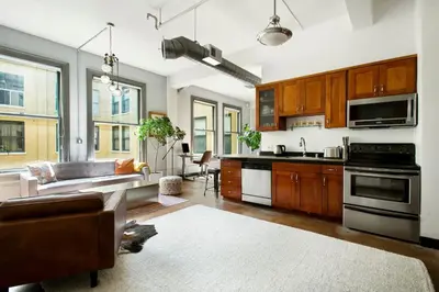 a kitchen and living room with a couch and a table at City Lights Loft Downtown LA Month Plus in Los Angeles