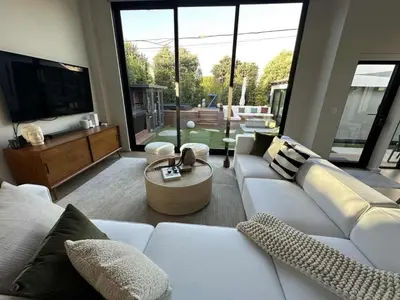 a living room with a white couch and a large window at Zenice Beach Luxury Home - Sauna, Cold Plunge, Spa in Los Angeles