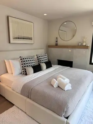 a bedroom with a large bed with two towels on it at Zenice Beach Luxury Home - Sauna, Cold Plunge, Spa in Los Angeles